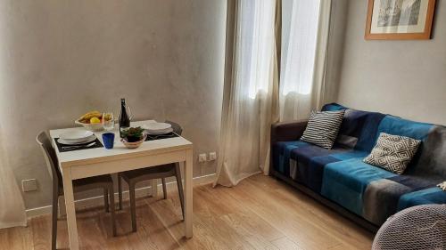 un soggiorno con tavolo e divano blu di San Giovanni Novo Apartments a Venezia
