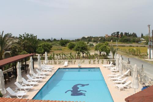 a swimming pool with lounge chairs and a resort at Club Alda in Lapithos