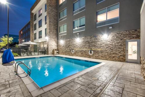 einem Pool vor einem Gebäude in der Unterkunft Holiday Inn Express & Suites Dallas North - Addison, an IHG Hotel in Addison