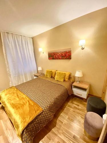 a bedroom with a bed with yellow sheets and a window at Vaļņu Ielas Apartments in Cēsis