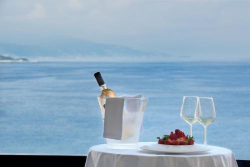 a bottle of wine and two glasses on a table at Columbus Hotel Monte-Carlo, Curio Collection by Hilton in Monte Carlo
