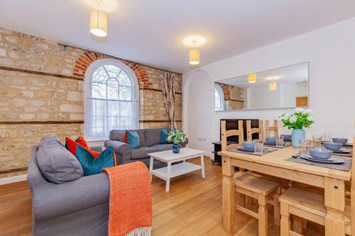 a living room with a couch and a table at Unique and quirky central apartment with parking in Oxford