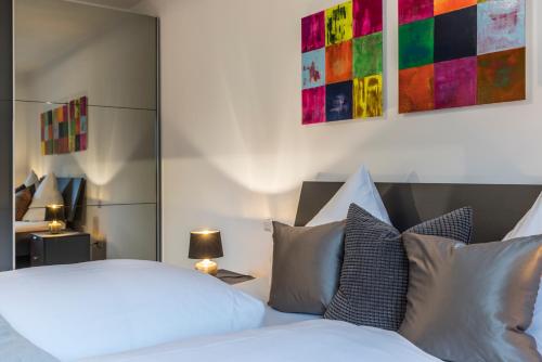 a bedroom with a white bed with pillows at RH-Appartements 15 Minuten von Basel im Dorf Rührberg in Grenzach-Wyhlen