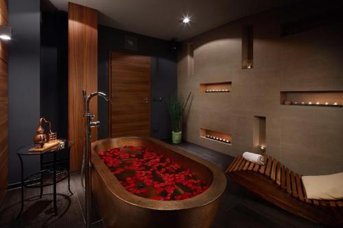 a bathroom with a tub filled with red roses at Spa Hotel Felicitas in Poděbrady