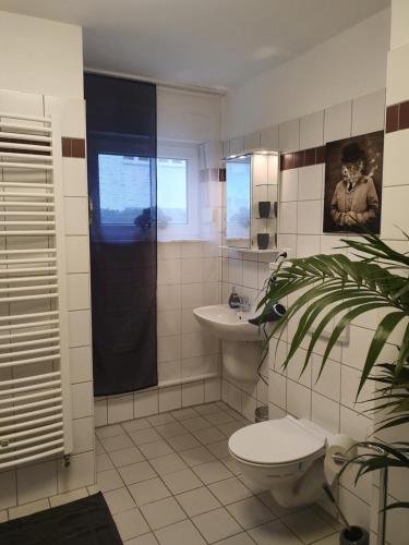 a bathroom with a toilet and a sink at Black & Wood Design FeWo im Zentrum in Cottbus