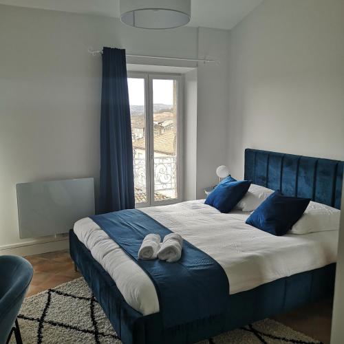 1 dormitorio con 1 cama grande con almohadas y zapatos azules en Suite Mermoz -T3- Belle vue - Billard-wifi-Vélo en Castelnaudary
