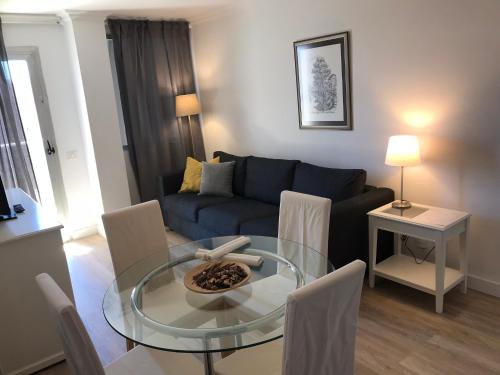 uma sala de estar com uma mesa de vidro e um sofá em Apartamentos Bruja em Santa Cruz de Tenerife