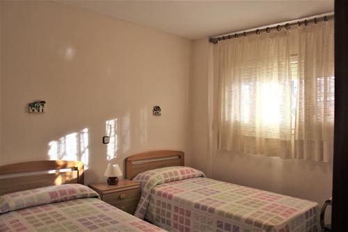 トラダンバーラにあるApartaments Lamoga - Monteixoのベッドルーム1室(ツインベッド2台、窓付)