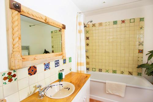 a bathroom with a sink and a tub and a mirror at Vinegar Hill Pottery in Lymington