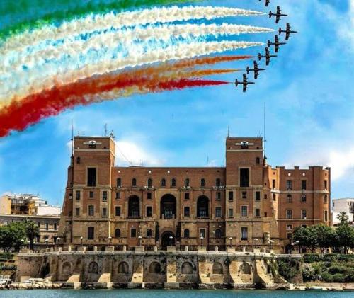 a group of planes flying in formation in front of a building at Belle Époque in Taranto