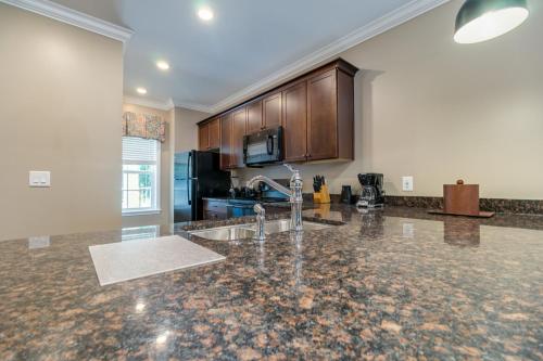 a kitchen with a marble counter top and wooden cabinets at Holiday Inn Club Vacations Williamsburg Resort in Williamsburg
