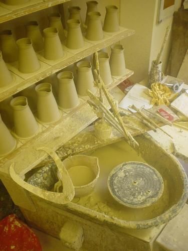 a dirty sink with a bunch of vases on shelves at Vinegar Hill Pottery in Lymington