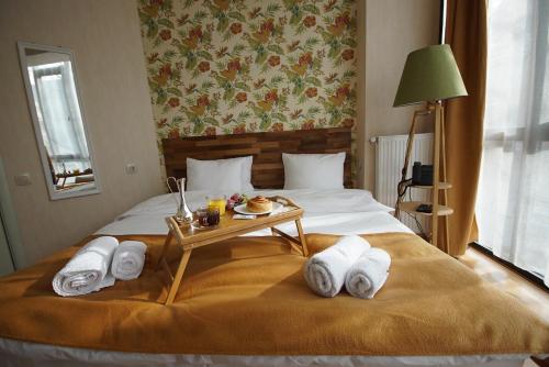 a bed with towels and a tray of food on it at Hotel Cordata in Tbilisi City