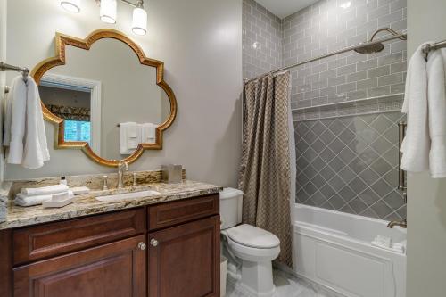 a bathroom with a toilet and a sink and a mirror at Holiday Inn Club Vacations Williamsburg Resort, an IHG Hotel in Williamsburg