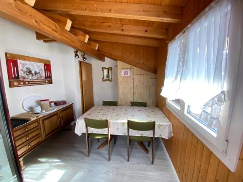 einen Tisch und Stühle in einem kleinen Zimmer mit Fenster in der Unterkunft Privatzimmer / bed & breakfast in Andermatt