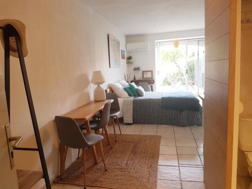 una camera da letto con un letto, un tavolo e una scrivania di le petit Eden de la Madrague face à la Ciotat a Saint-Cyr-sur-Mer