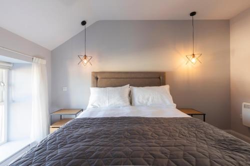 a bedroom with a large bed with two lamps at Rooms at the Lower House in Dungannon