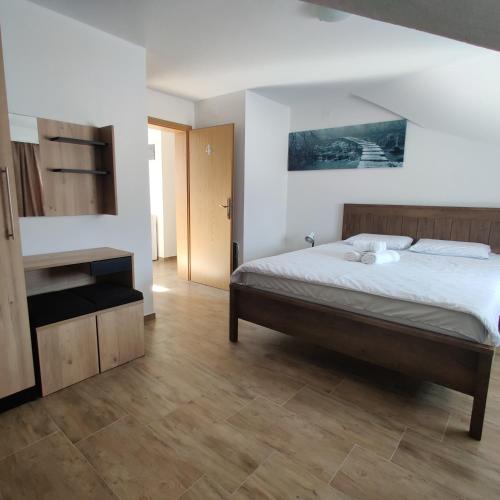 1 dormitorio con 1 cama y suelo de madera en Guest House Šapina, en Korenica