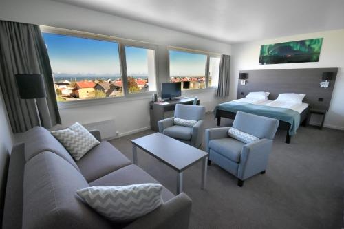 a hotel room with two beds and a couch and chairs at Thon Partner Hotel Andrikken in Andenes