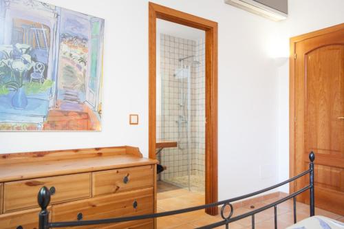 a bathroom with a wooden dresser and a shower at Correfoc in Sa Pobla