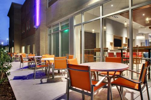 an outdoor patio with tables and chairs and windows at Holiday Inn Express & Suites Charleston NE Mt Pleasant US17 by IHG in Charleston