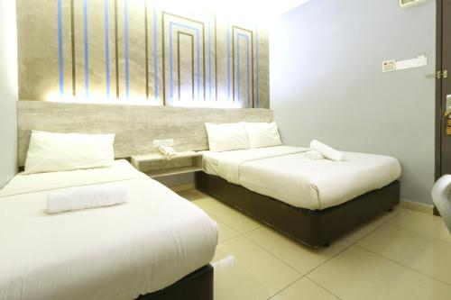 a hotel room with two beds and a phone at Suite Dreamz Hotel in Kuala Lumpur