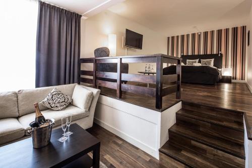 a living room with a couch and a bed at First Hotel Witt in Kalmar