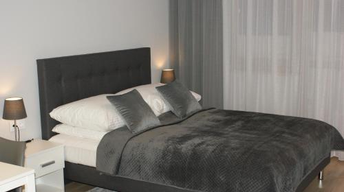 Un dormitorio con una cama en blanco y negro y una ventana en Apartament Agata, en Świnoujście