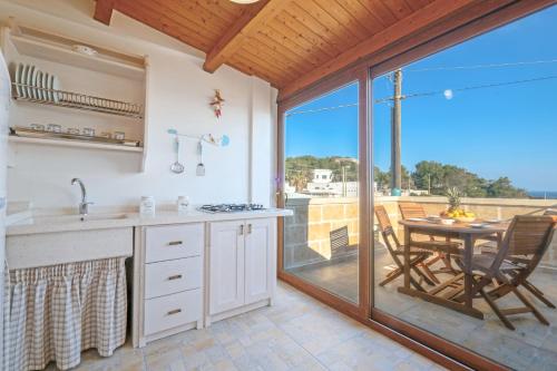 a kitchen with a view of a patio with a table at Una Torre nel Mare in Gagliano del Capo