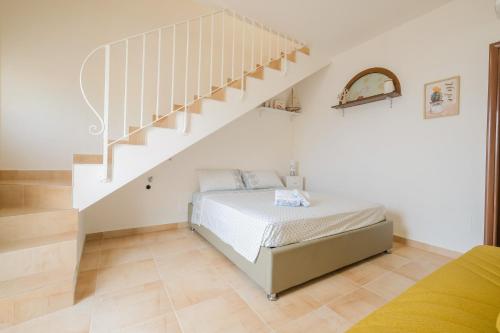 a bedroom with a bed and a staircase at Una Torre nel Mare in Gagliano del Capo