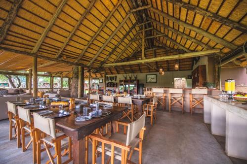 a restaurant with a large wooden table and chairs at Shindzela Tented Camp in Timbavati Game Reserve