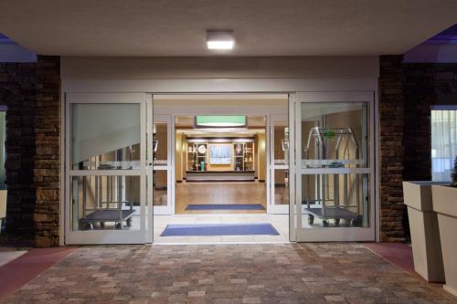 an entrance to a building with glass doors at Holiday Inn Express Hotel & Suites Huntsville West - Research Park by IHG in Huntsville