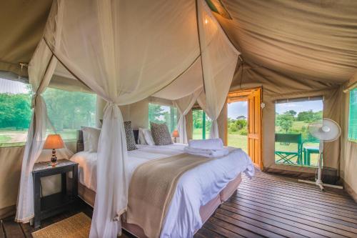 a bedroom with a bed in a tent at Shindzela Tented Camp in Timbavati Game Reserve