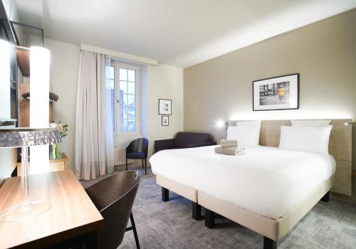 Un pat sau paturi într-o cameră la Mercure Rennes Centre Place Bretagne