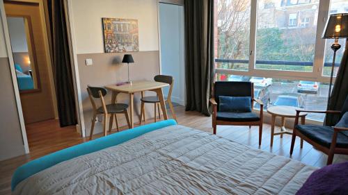 une chambre avec un lit, une table et des chaises dans l'établissement Little Suite - Constance, à Lille