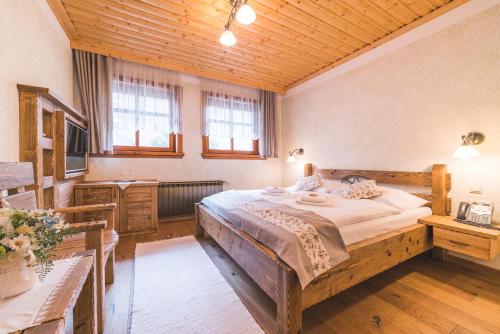 ein Schlafzimmer mit einem großen Bett und einer Holzdecke in der Unterkunft Salaš Syrex in Zázrivá