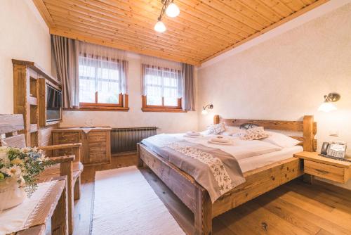 una camera da letto con un letto grande e un soffitto in legno di Salaš Syrex a Zázrivá