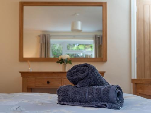 a towel sitting on a bed in front of a mirror at New Peny in Llandrindod Wells