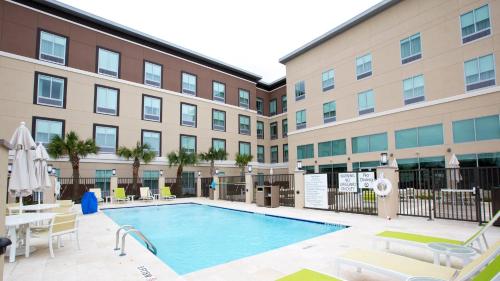 a swimming pool in front of a building with a hotel at Holiday Inn Express & Suites Houston NW - Hwy 290 Cypress by IHG in Cypress