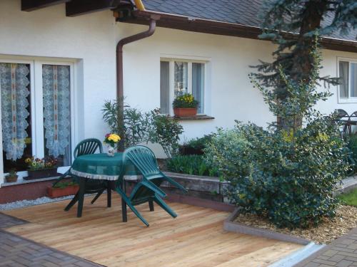 a patio with a table and chairs on a deck at Ferienwohnungen An den Linden in Burg