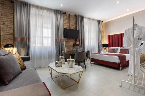 Habitación de hotel con cama y sofá en BiBo Suites Plaza Nueva en Granada