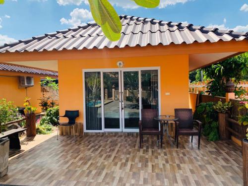 a house with a patio with a table and chairs at All Times Pool Villa in Ban Ta Khun