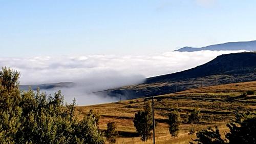 uma vista para uma montanha com nuvens num campo em Thaba Lapeng Mountain Escape em Clarens