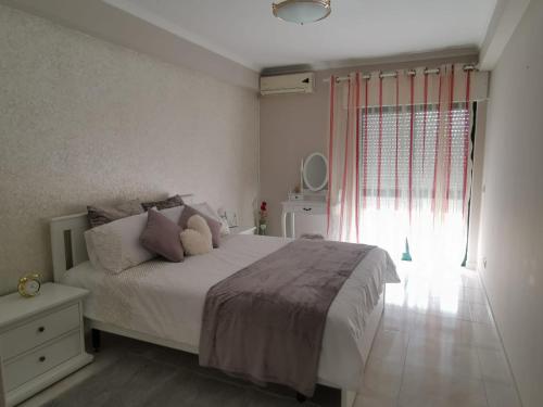 een slaapkamer met een wit bed en een raam bij Penha House in Faro