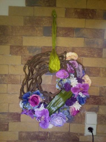 a wreath of flowers on a brick wall at Gästehaus Auszeit in Unterlamm