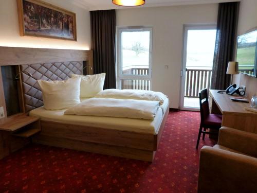 a hotel room with a bed and a desk at Ferienhotel Wolfsmühle in Rodishain