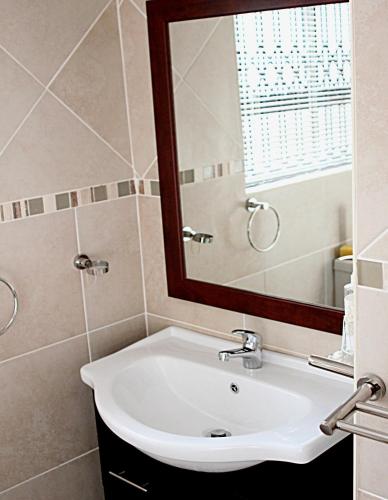 ein Badezimmer mit Waschbecken und Spiegel in der Unterkunft Tuscany By The Sea in Port Edward