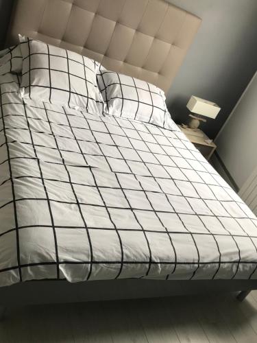 - un lit avec une couette en noir et blanc dans l'établissement Appartement Standing 40 mètres Plage Terrasse et Garage avec wifi, à Pléneuf-Val-André