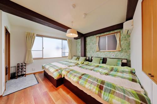a bedroom with two beds and a window at Terrace Terano#201 in Tokyo