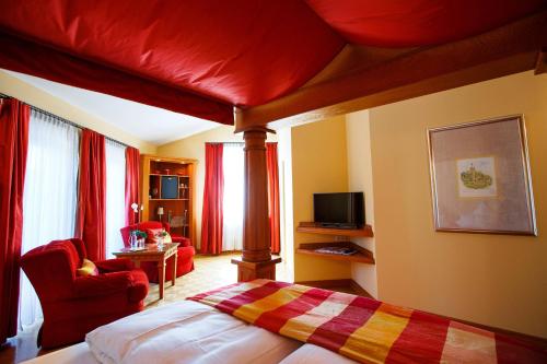 a bedroom with a canopy bed and a living room at Burg & Gästehaus by Schwarzenstein in Geisenheim